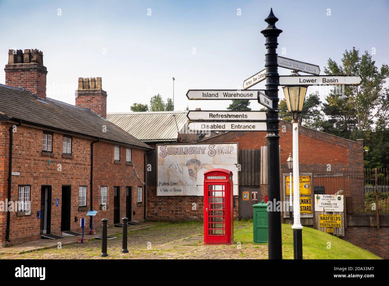 UK, England, Cheshire, Ellesmere Port, National Waterways Museum, Porter's Row cottages, signpost and restored K6 phone box Stock Photo