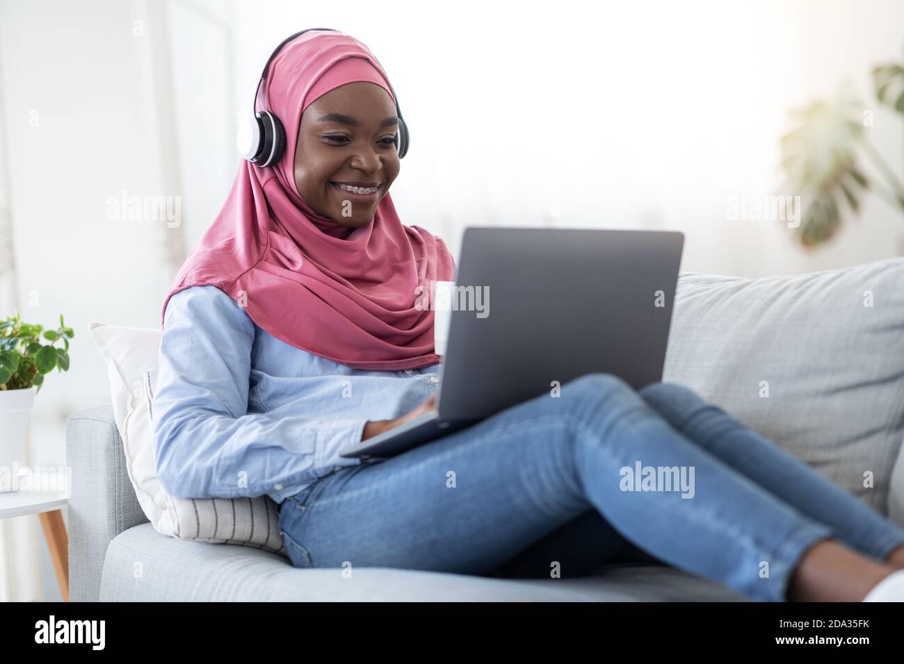 Home Pastime. Black Muslim Woman In Hijab Relaxing With Laptop And ...