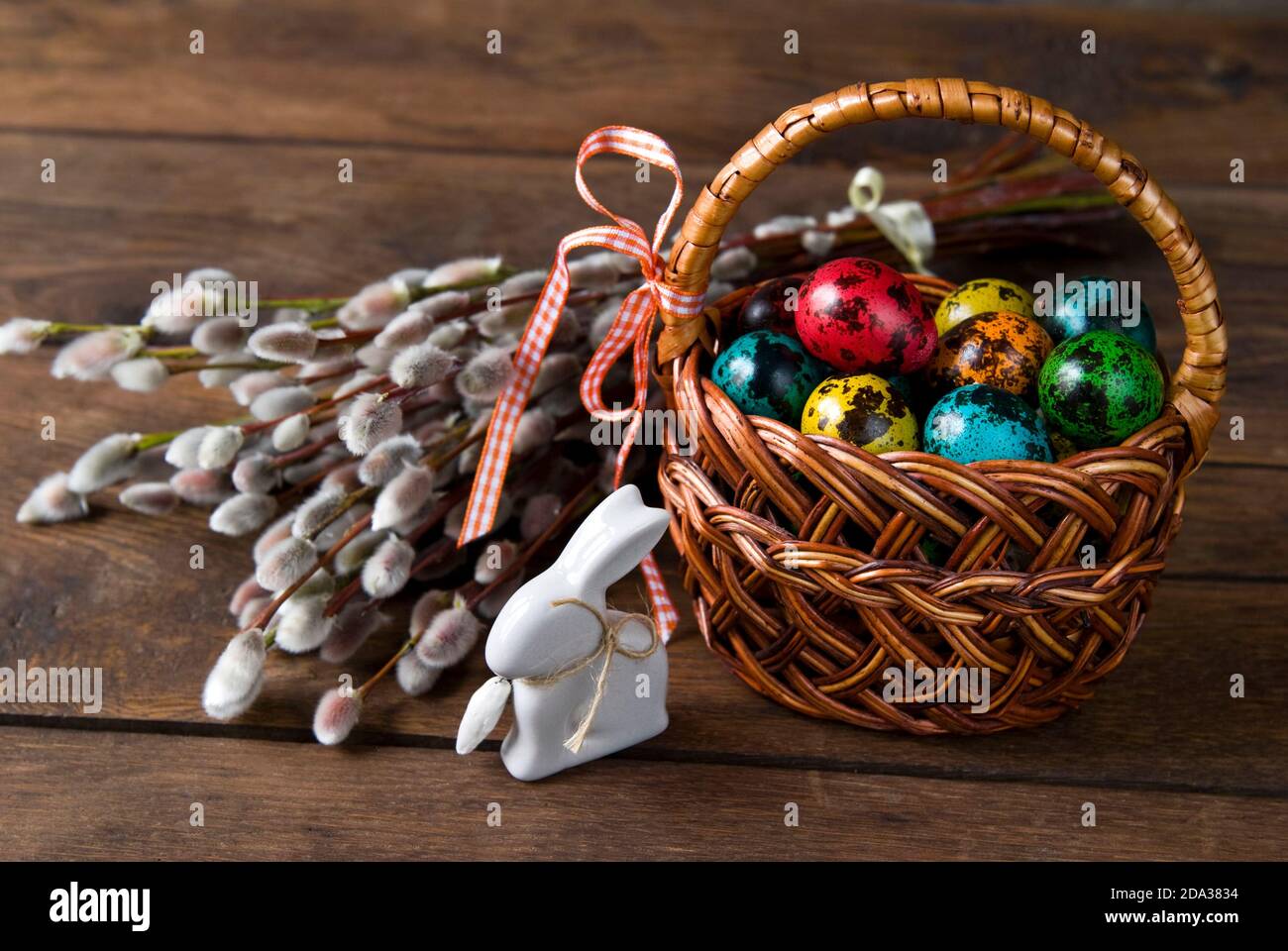 Wicker basket with Easter eggs and willow twigs bouquet Stock Photo - Alamy