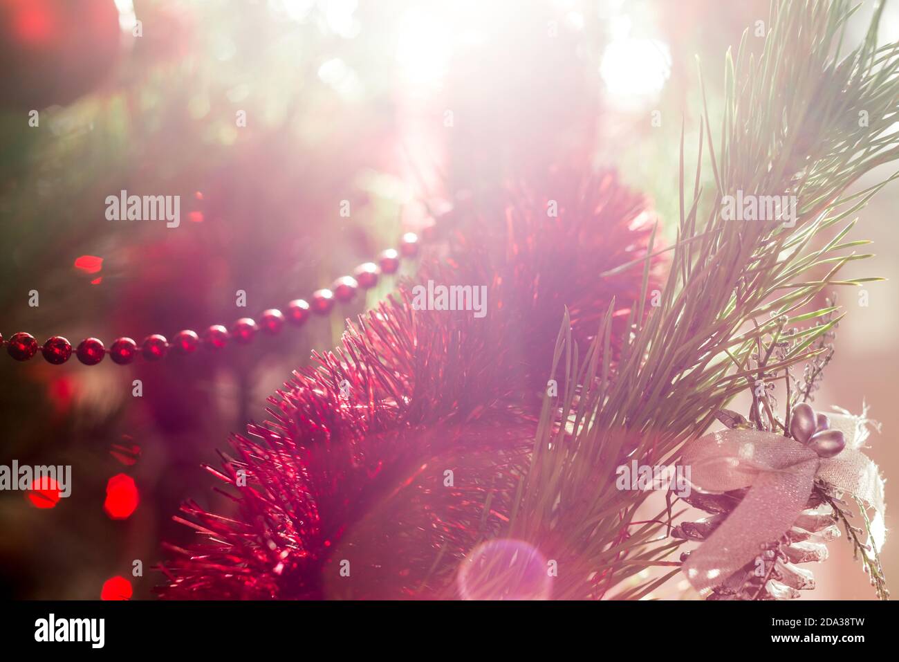 Christmas or New Year red decorative ball on a festively decorated tree. Christmas background. Selective soft focus. Bokeh Stock Photo