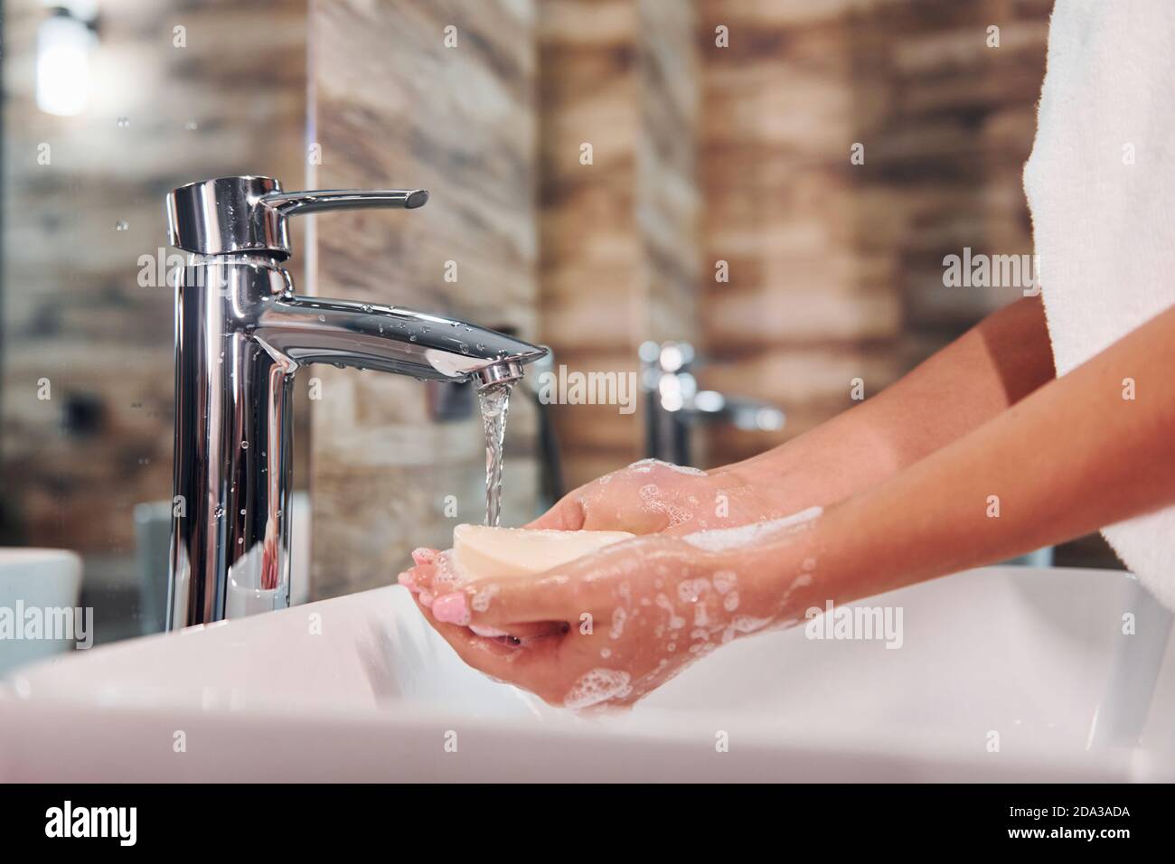 Close up view of woman that standing in bathroom and washing hands ...