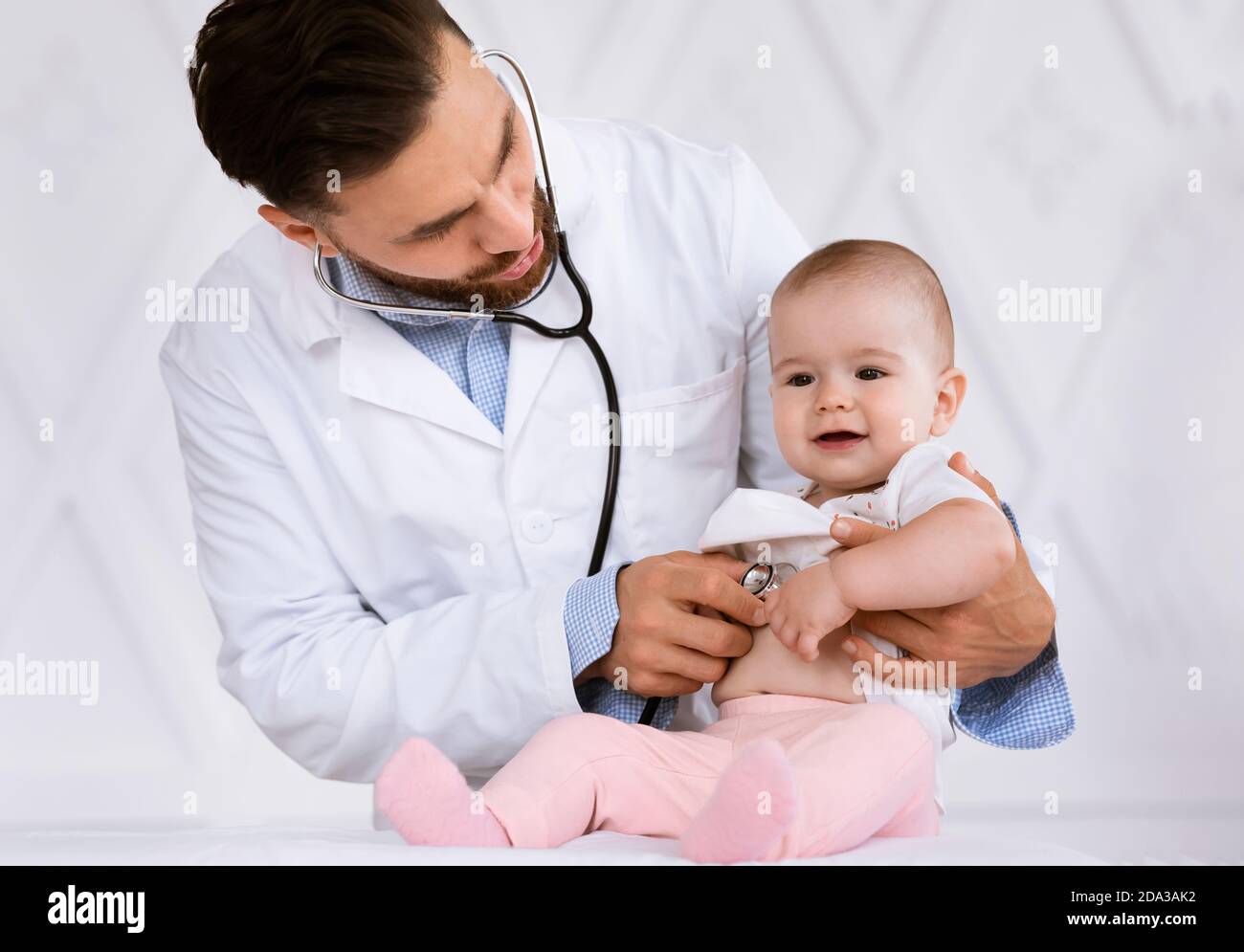 Doctor Examining Baby Listening To Heartbeat With Stethoscope In Clinic