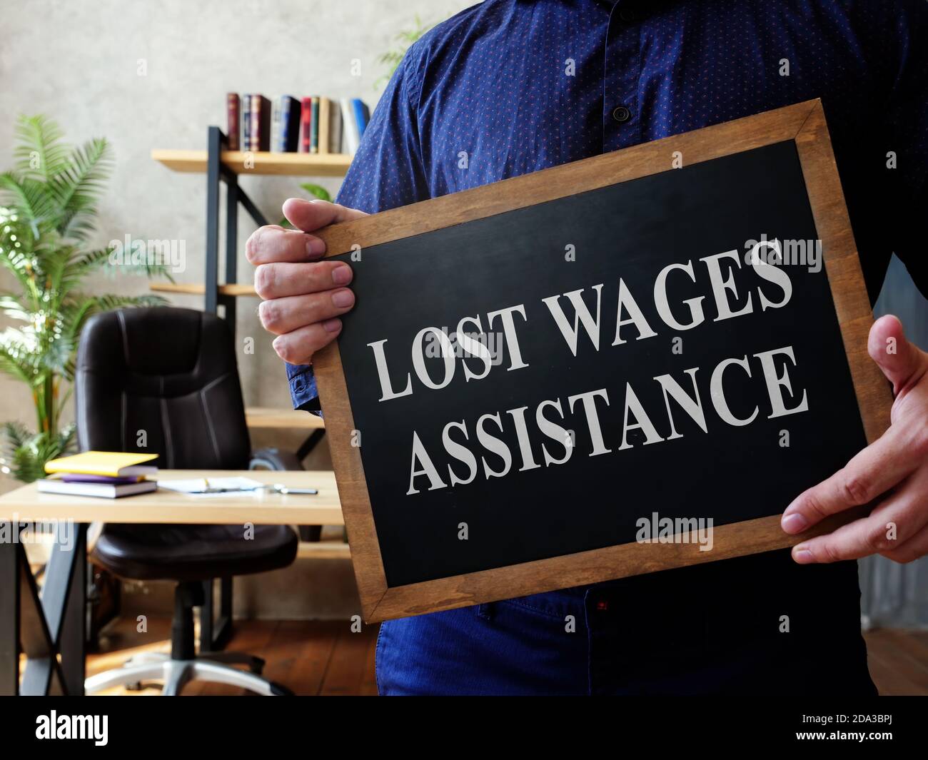 Man holds Lost Wages Assistance plate in the office. Stock Photo