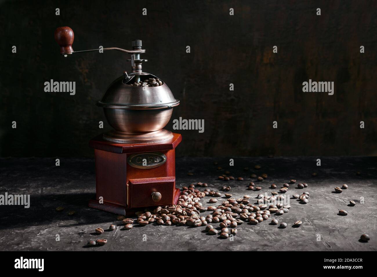 Nostalgic wooden coffee grinder and roasted coffee beans in side light ...