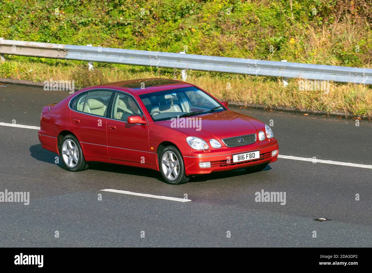 1999 90s red Lexus Gs300 SE Auto; Vehicular traffic, moving vehicles, cars, vehicle driving on UK roads, motors, motoring on the M6 motorway highway UK road network. Stock Photo