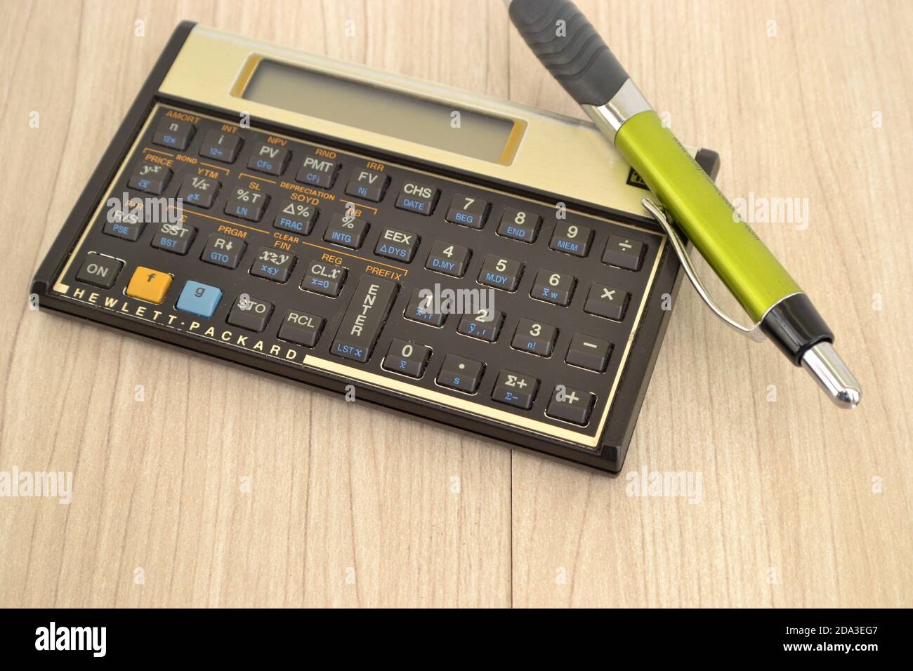 Electronic scientific calculator with pen, designed to calculate problems in science, engineering and mathematics on wooden background Stock Photo