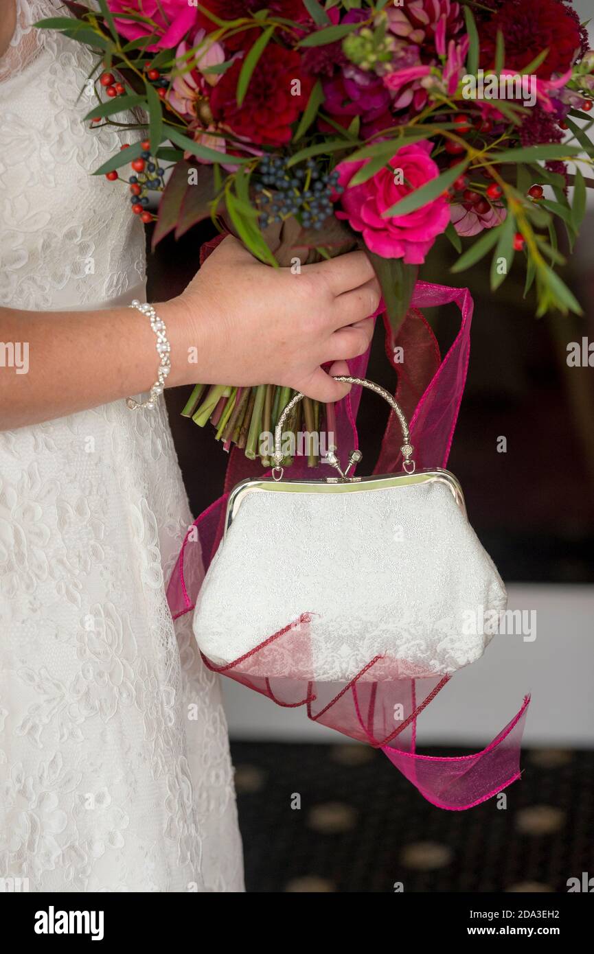 Close up of bridal bouquet and handbag at a wedding reception. Stock Photo