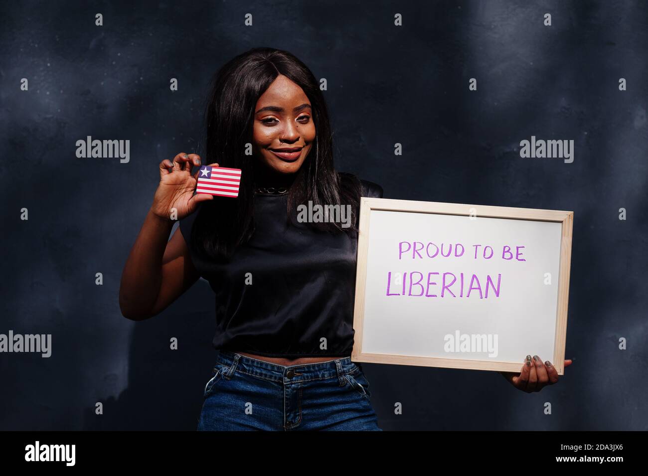 Proud to be liberian. Fashionable african woman hold board with Liberia flag. Stock Photo