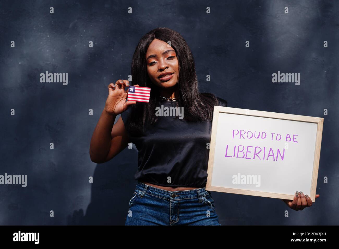 Proud to be liberian. Fashionable african woman hold board with Liberia flag. Stock Photo