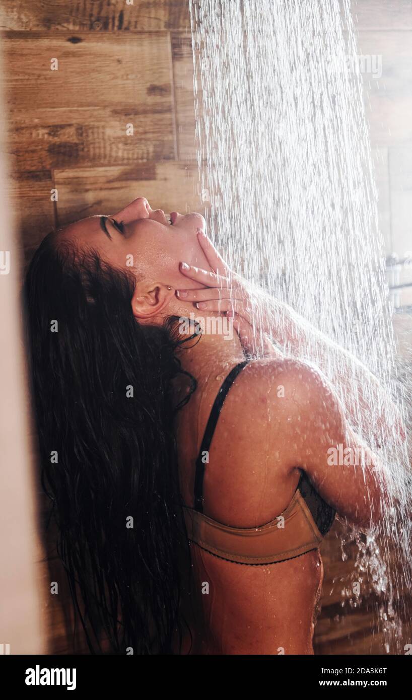 Pretty brunette with sexy slim body type in underwear taking a shower in spa Stock Photo