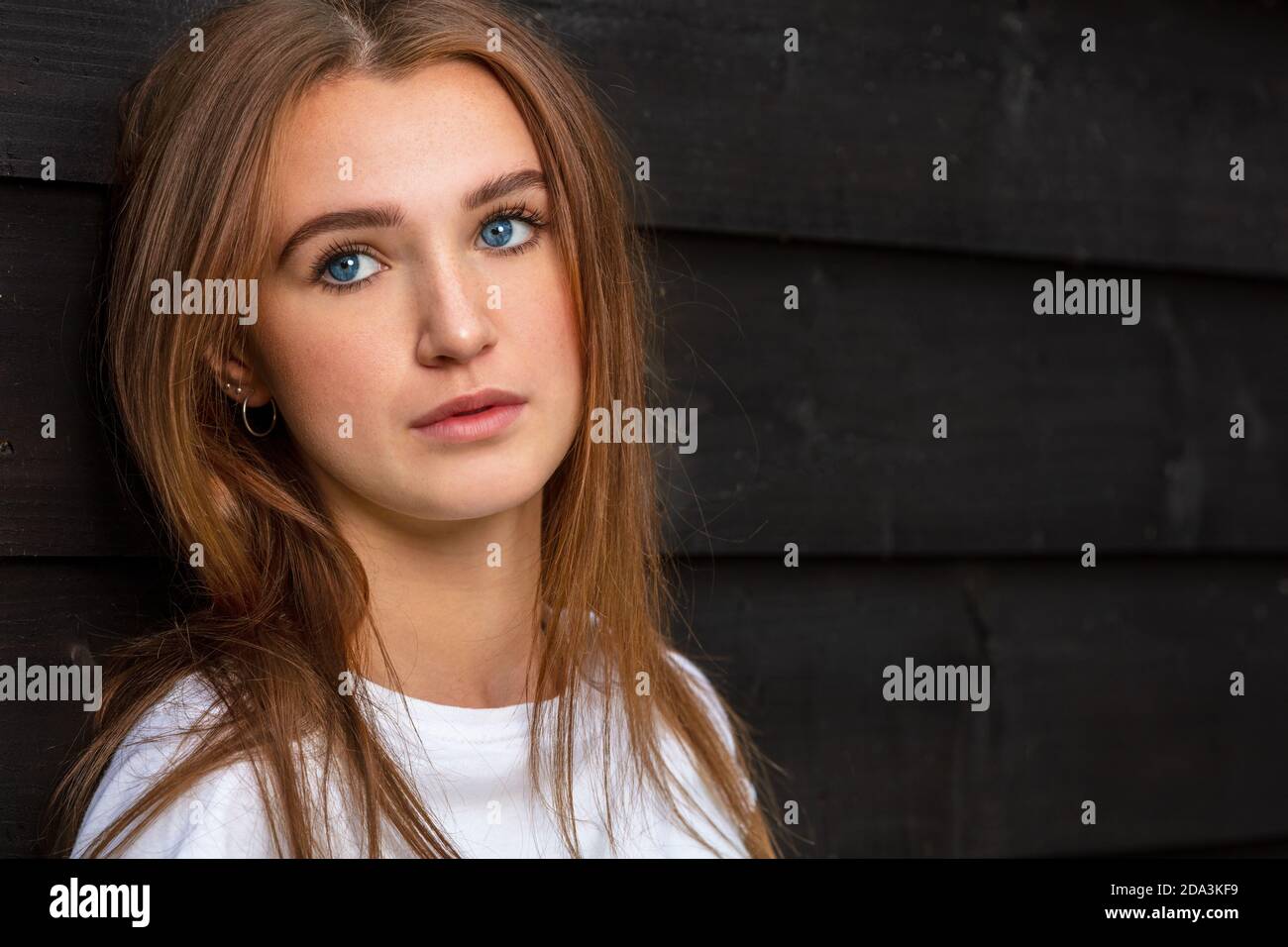 Sad depressed thoughtful girl teenager female young woman with blue eyes outside wearing a white t-shirt Stock Photo