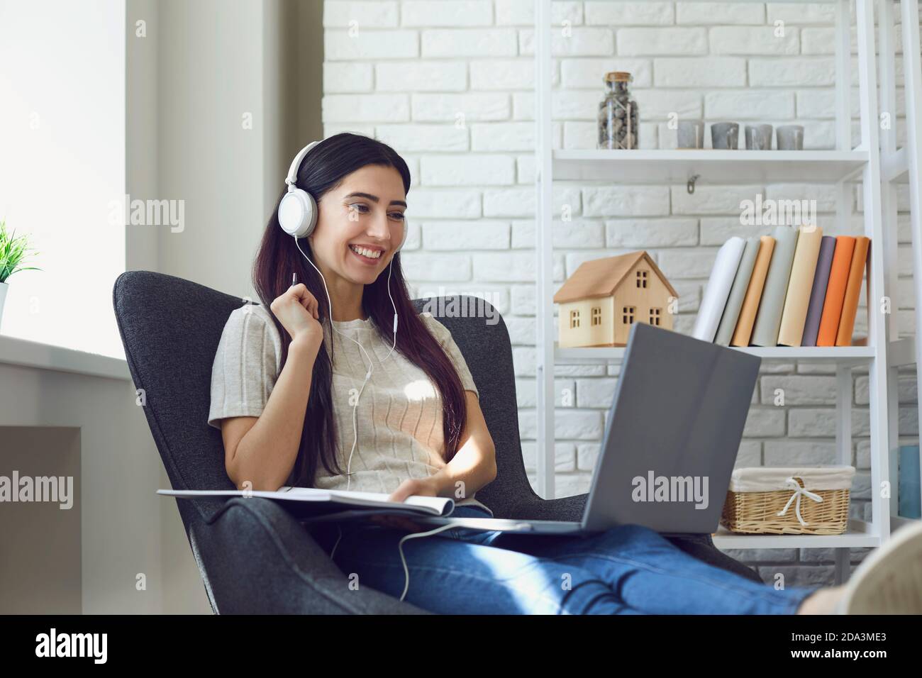 Young woman student attend online class, webinar or internet lecture from home using laptop computer Stock Photo
