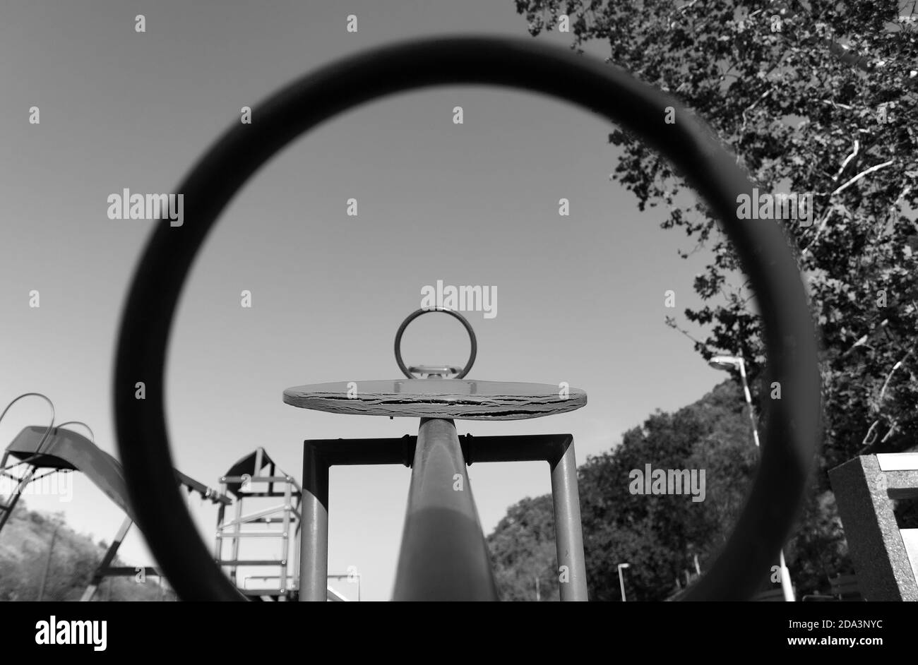 Abstract black and white photo of an empty kids playground. Two circles of teeter totter. Stock Photo