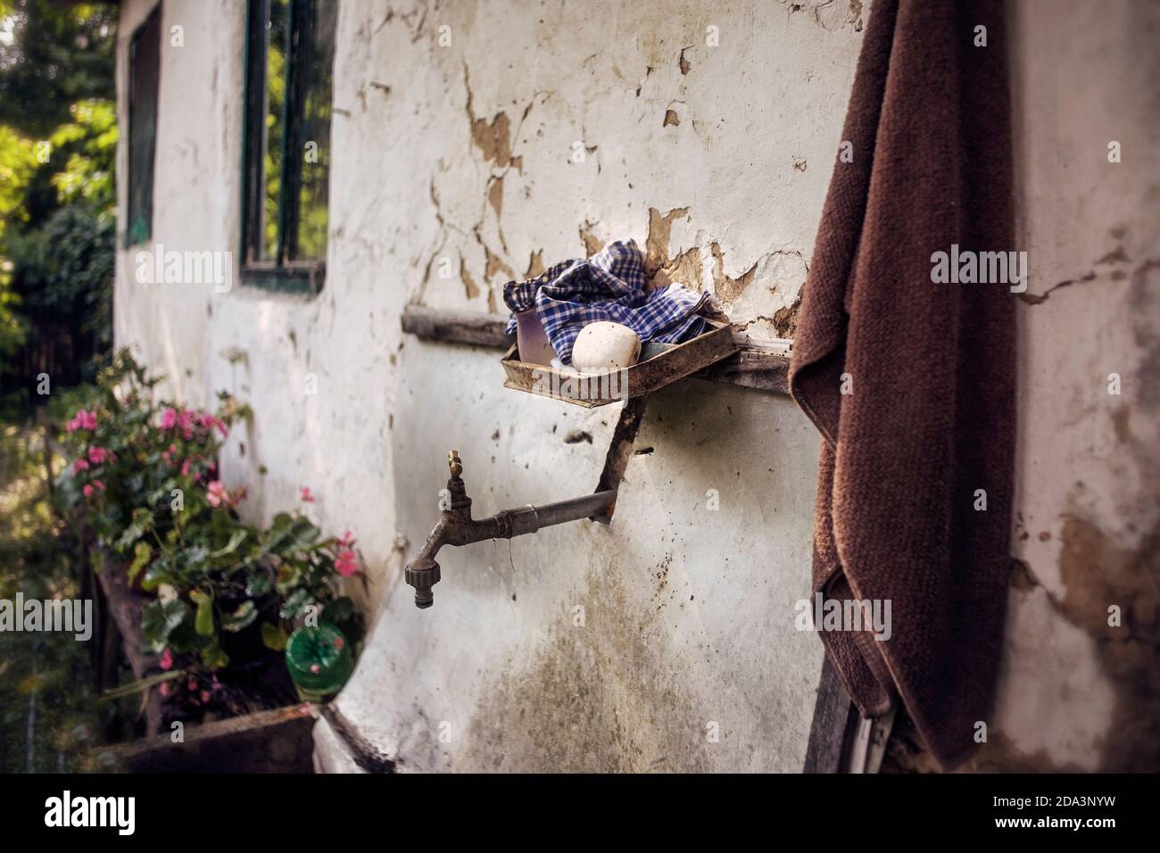 An outdoor faucet on a house wall with soap in a poor Serbian village. Stock Photo
