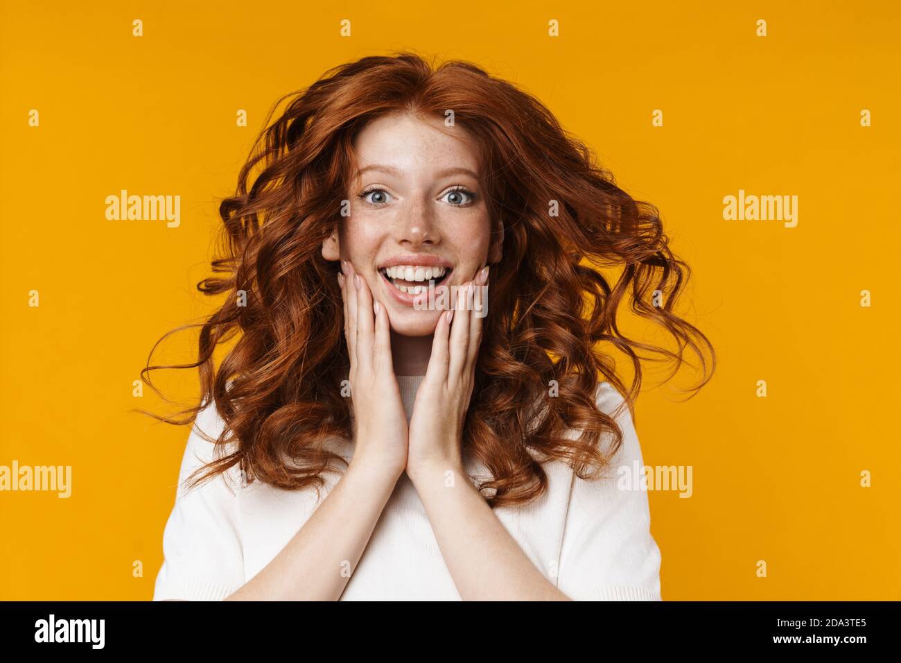 Image of redhead excited girl expressing surprise and looking at camera ...