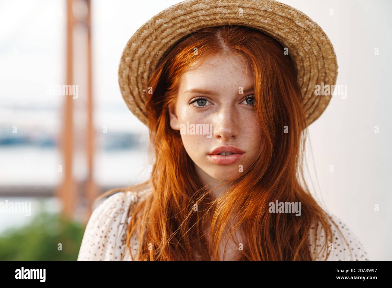 Image of young ginger girl in straw hat smiling and looking at camera ...