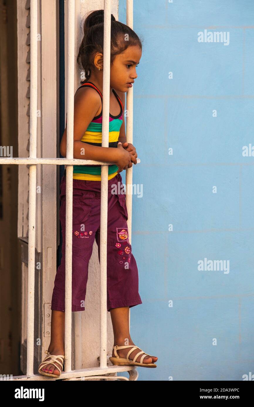 Cuba, Trinidad, Girl looking out of window grill at Casa de Culture Stock Photo