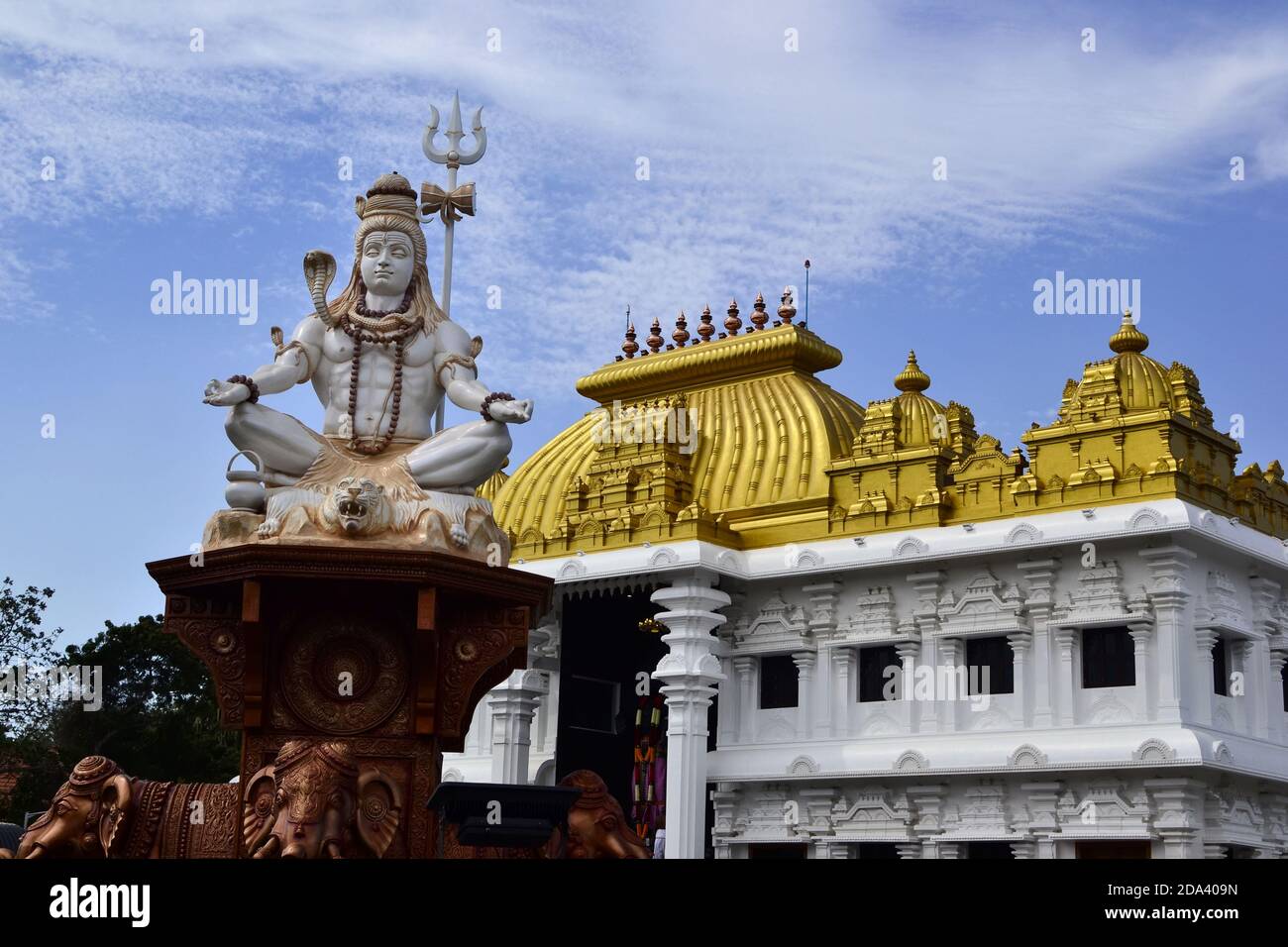 Shiva statue near hinduism temple with bright golden roof. Sri Ramayana Darshanam & BharatMata Sadanam, Kanyakumari, India Stock Photo