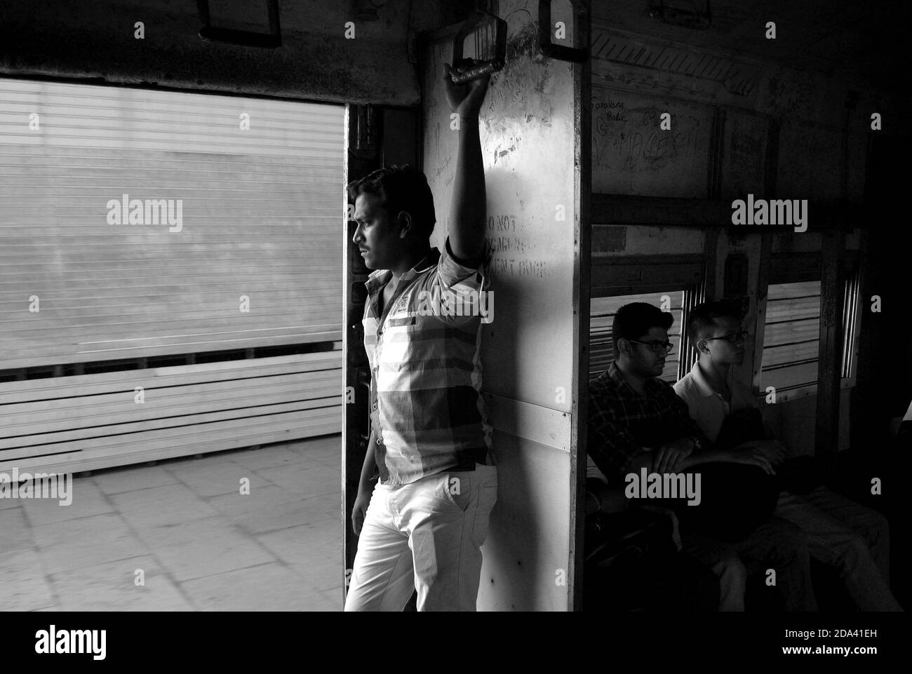 Chennai, Tamil Nadu, India - March, 2014: Portrait of Indin man inside city metro train with open doors. People in Chennai suburban train car. Made in Stock Photo