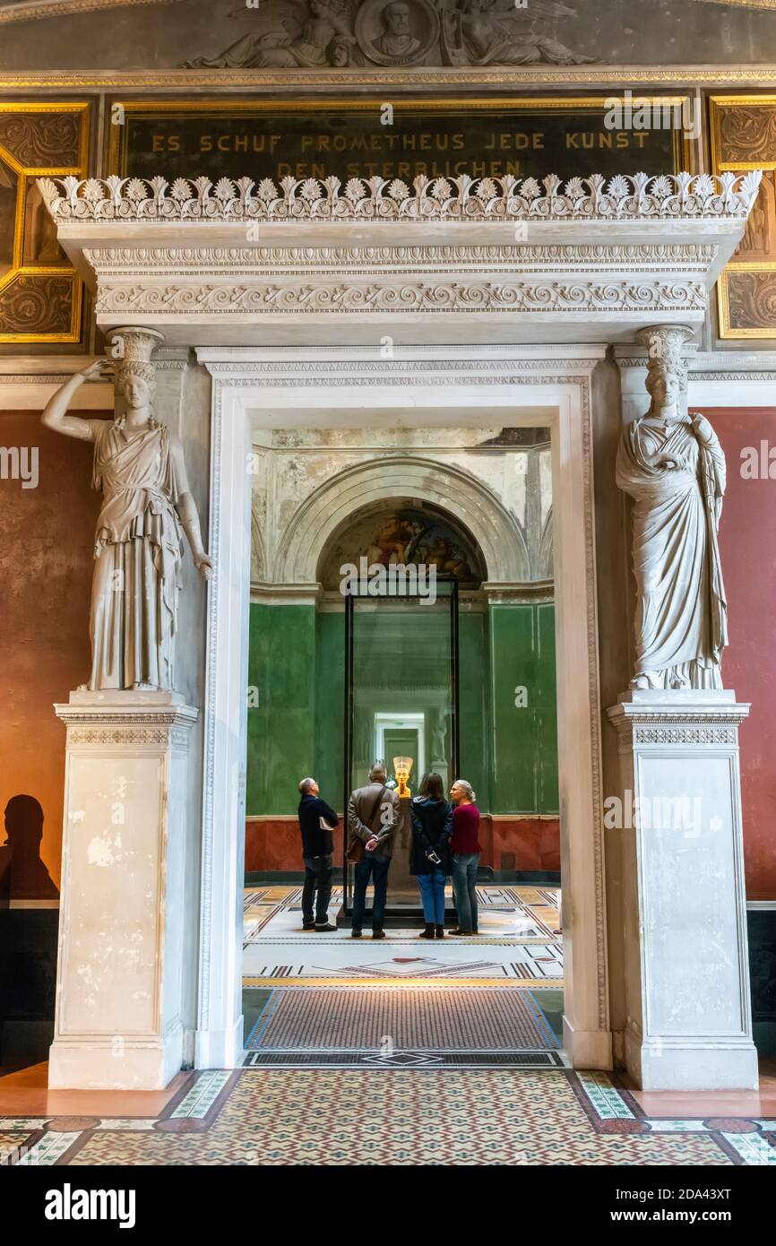 Berlin, Germany – January 29, 2018. Interior view of Neues Museum in Berlin, toward the bust of Egyptian queen Nefertiti, with people gathered around Stock Photo