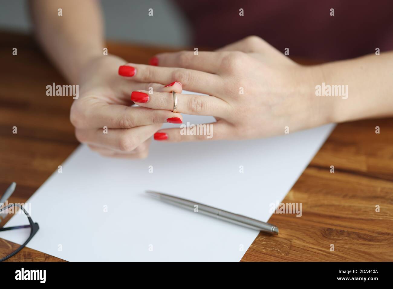 Woman's hand removes wedding ring from her finger. Stock Photo