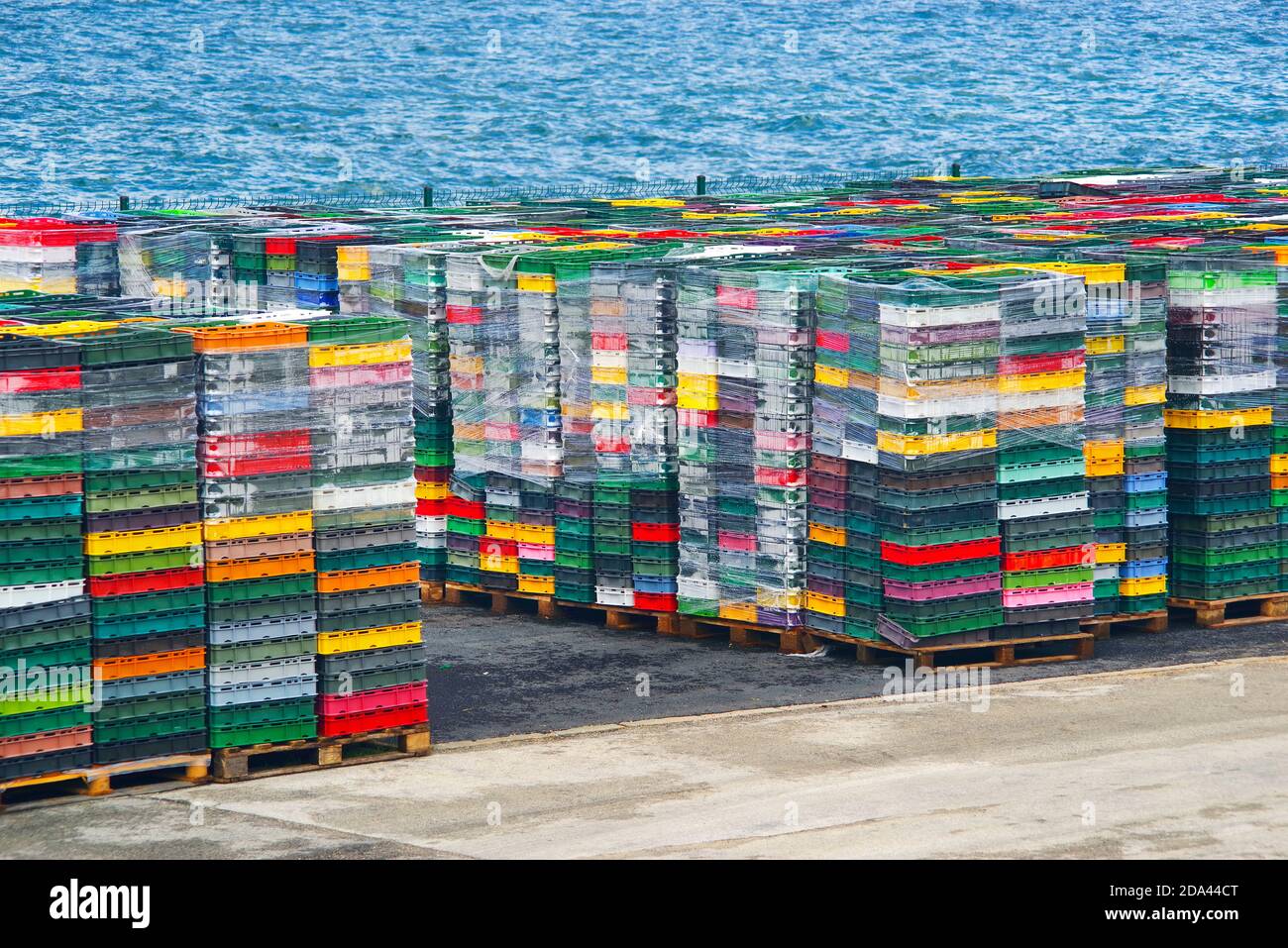 Colorful boxes plastic crates. Packing containers piles for fish storage of catch. Stock Photo