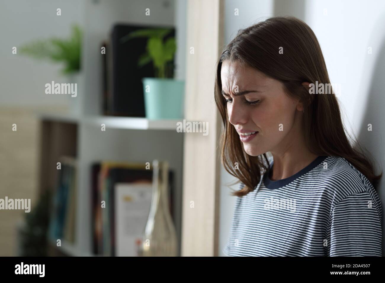 Sad girl crying alone standing at home in the night Stock Photo