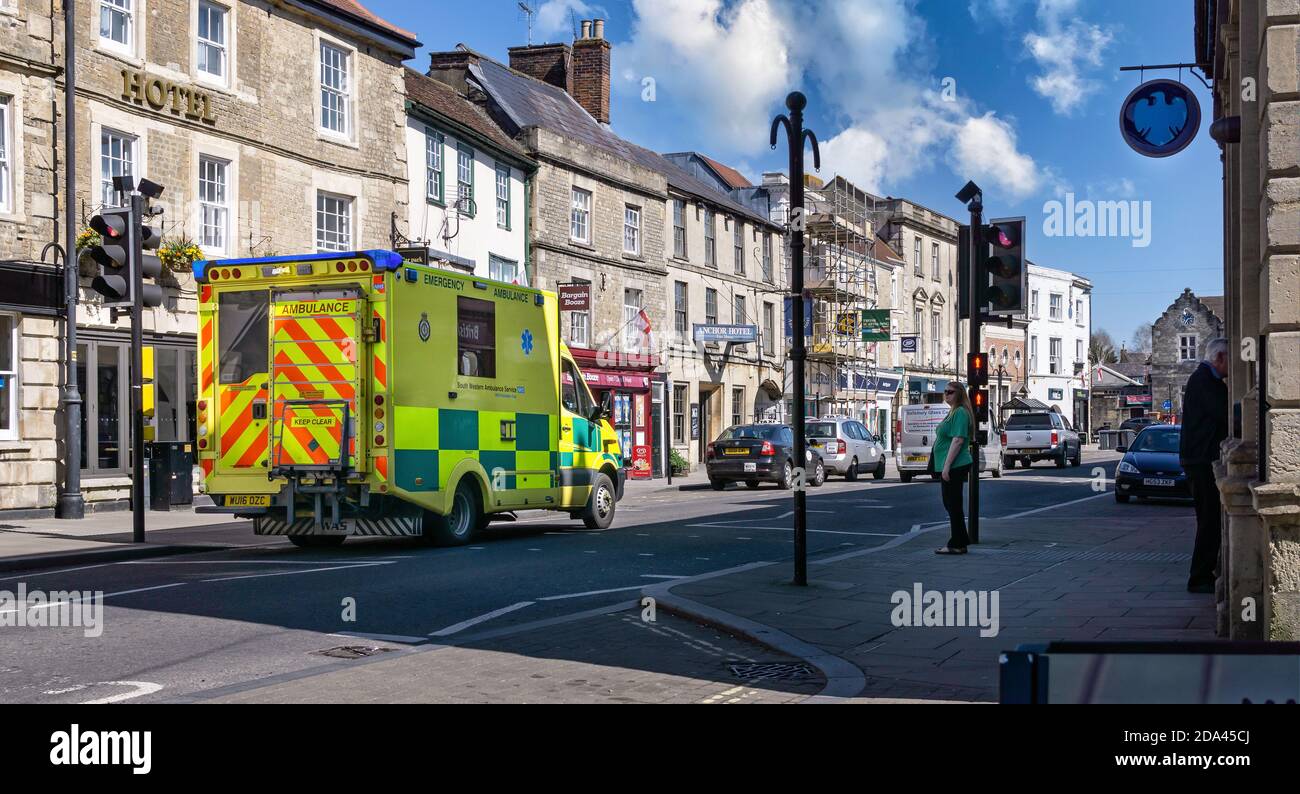 Emergency ambulance on call out with lights flashing through traffic