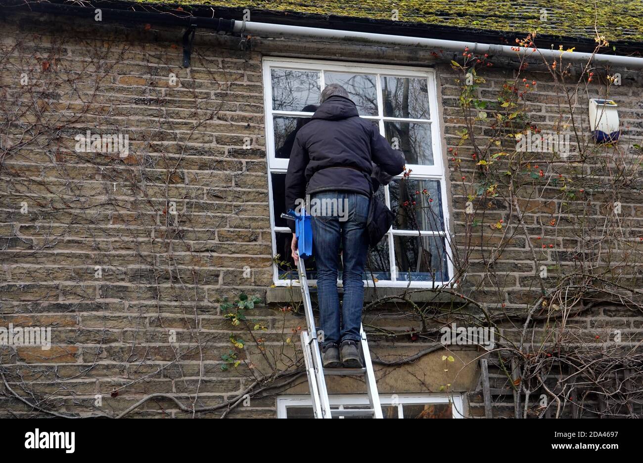 A window cleaner cleaning an upstairs window Stock Photo - Alamy
