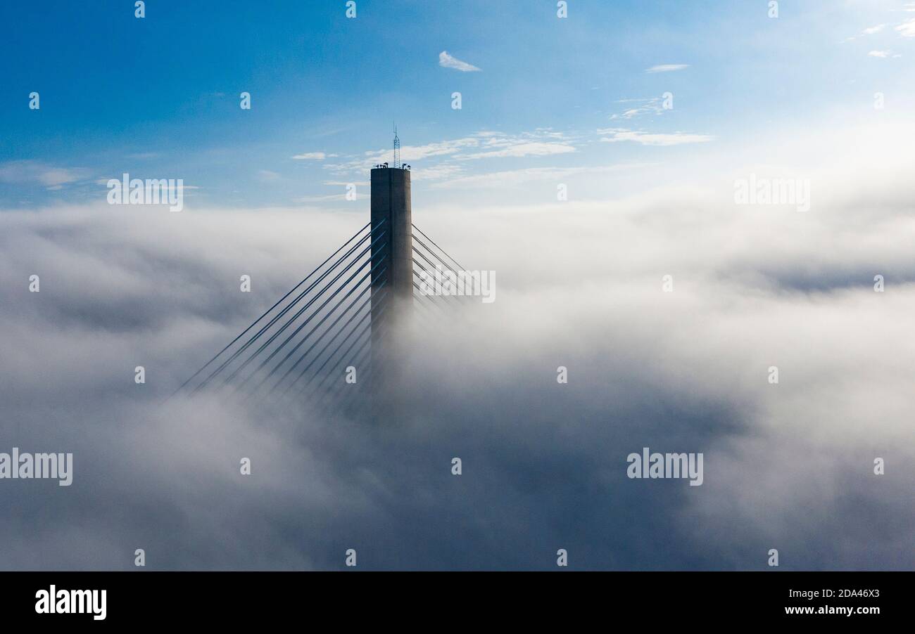 North Queensferry, Scotland, UK. 9 November 2020.The top of a tower of the Queensferry Crossing bridge manages to emerge above heavy fog over the Firth of Forth today. Edinburgh and the Lothians were covered in thick fog all day.  Iain Masterton/Alamy Live News Stock Photo