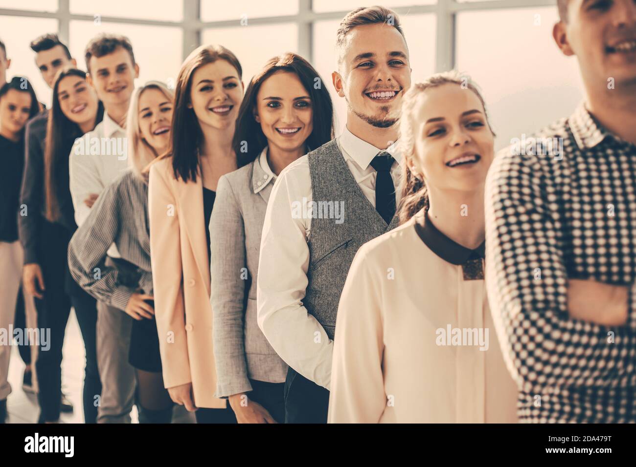 group of diverse young people standing in a long queue Stock Photo
