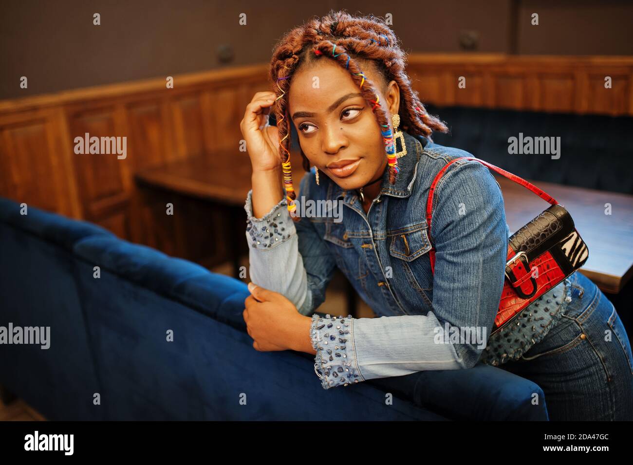 Lovely african american woman with dreadlocks in blue stylish jeans jacket  at cafe. Beautiful cool fashionable black young girl indoor Stock Photo -  Alamy