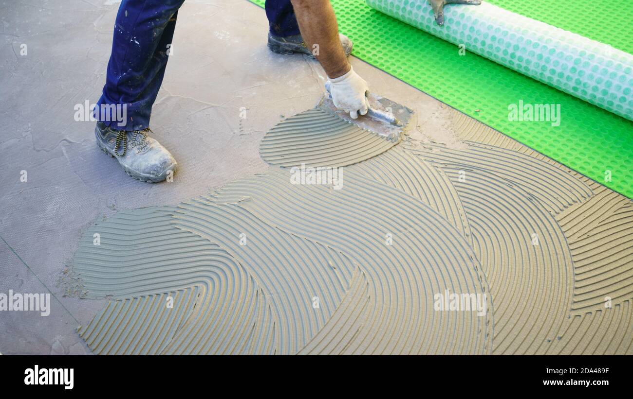worker applying tile adhesive glue on the floor Stock Photo Alamy