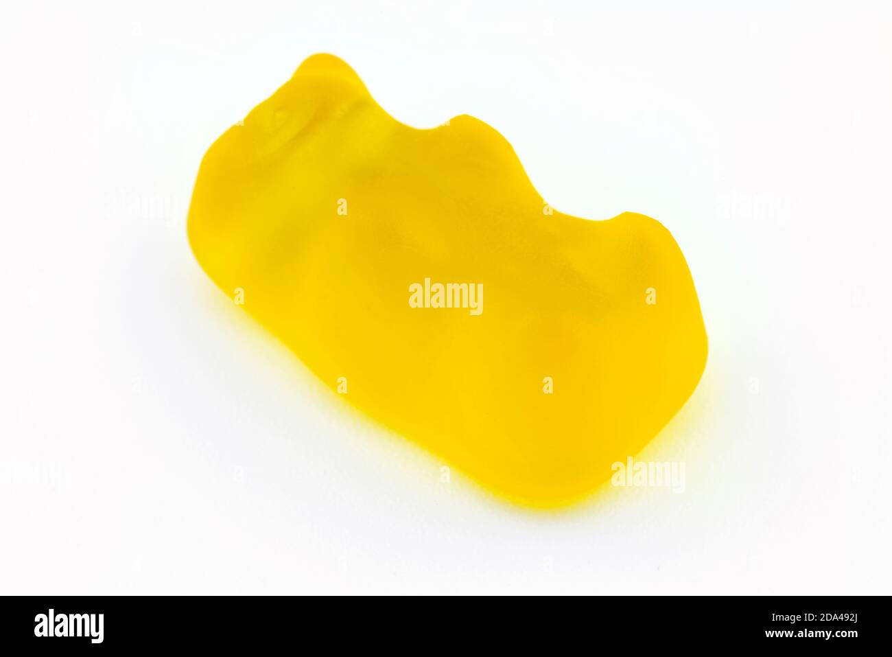 A macro shot of a yellow gummy bear, isolated on a white background. Stock Photo