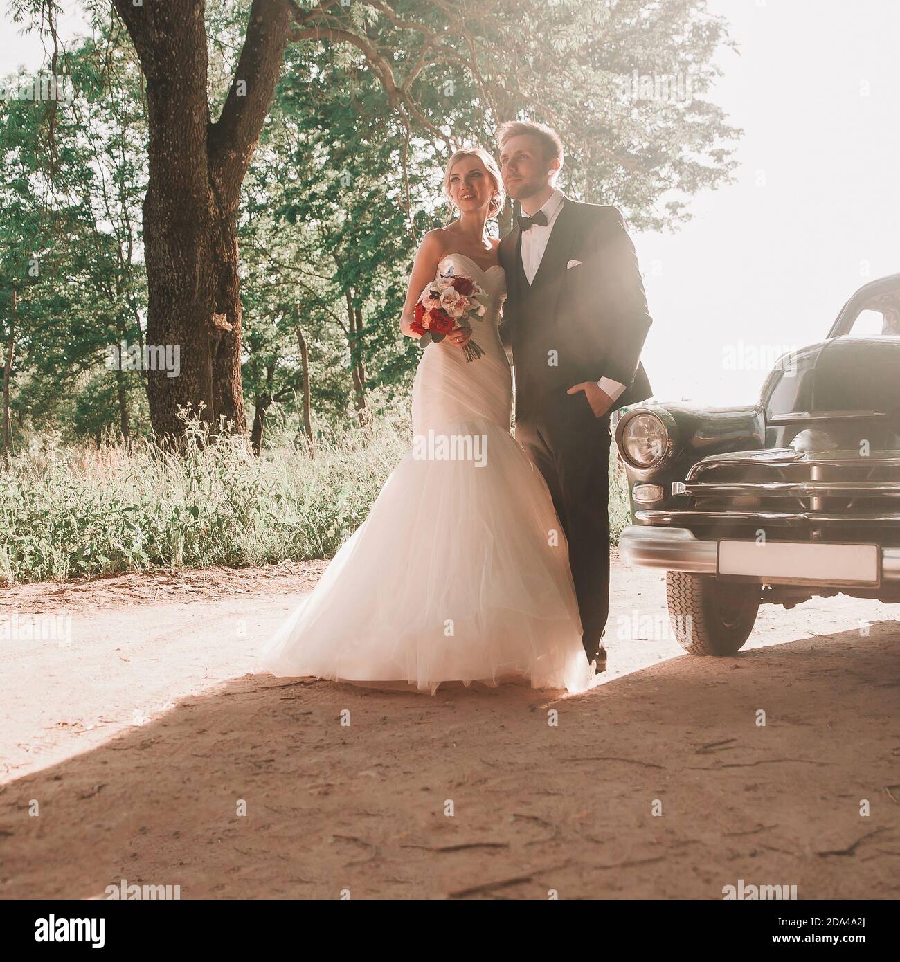 happy bride and groom standing on the side of the road Stock Photo - Alamy
