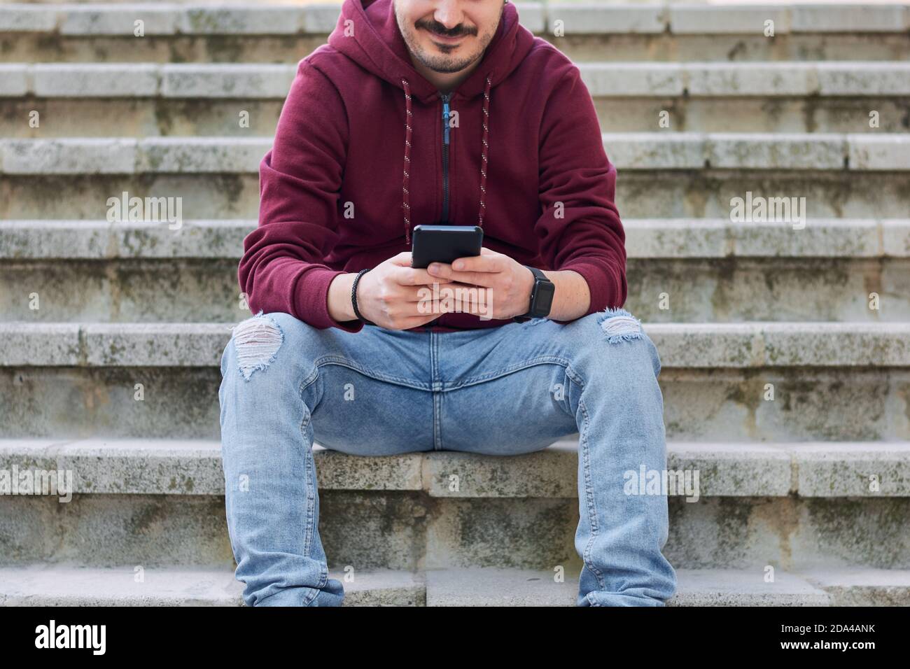 Unrecognizable man types on his cell phone Stock Photo