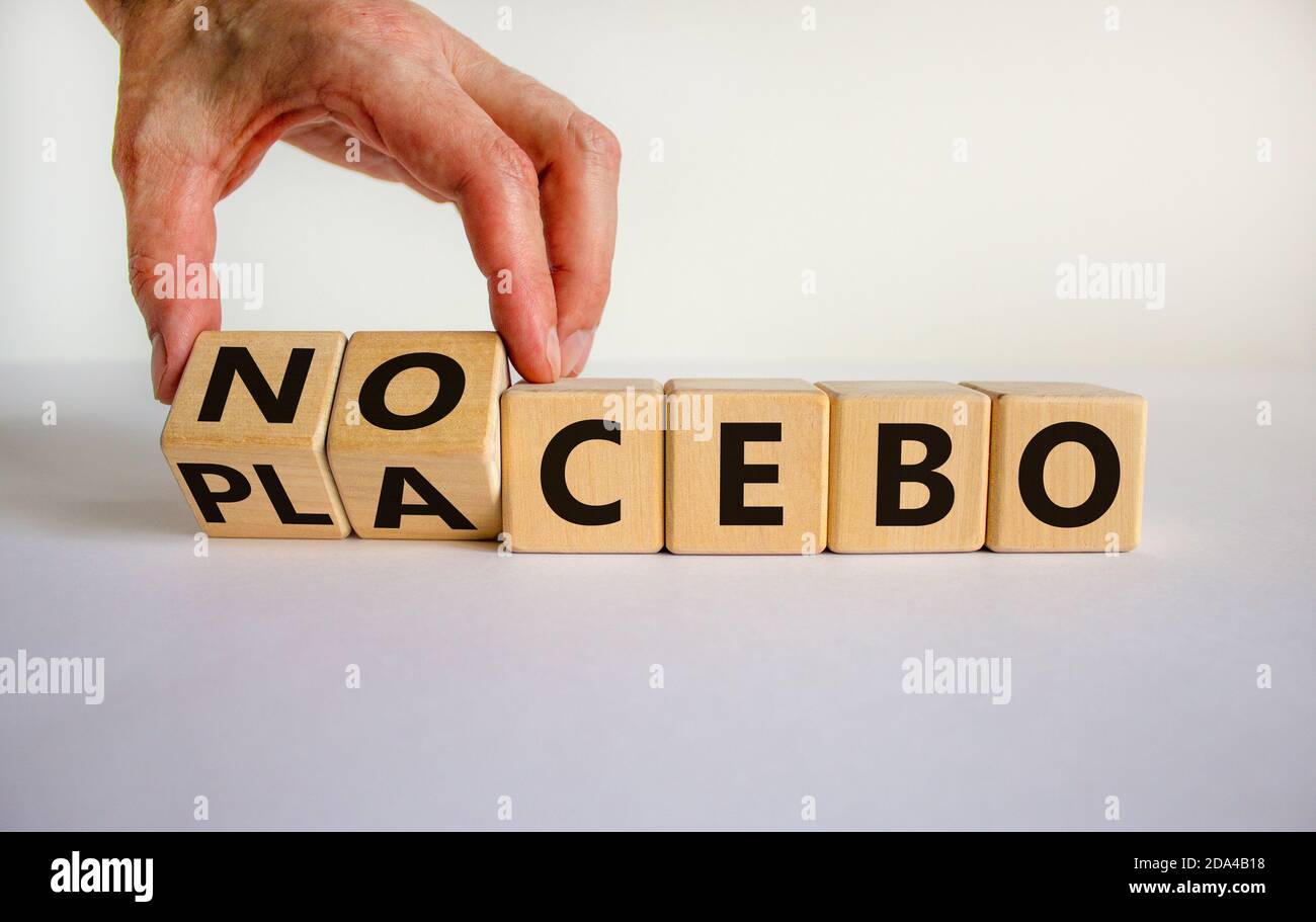 Nocebo or placebo. Male hand turnes cubes and changes the word 'placebo' to 'nocebo', or vice versa. Beautiful white background, copy space. Medical c Stock Photo