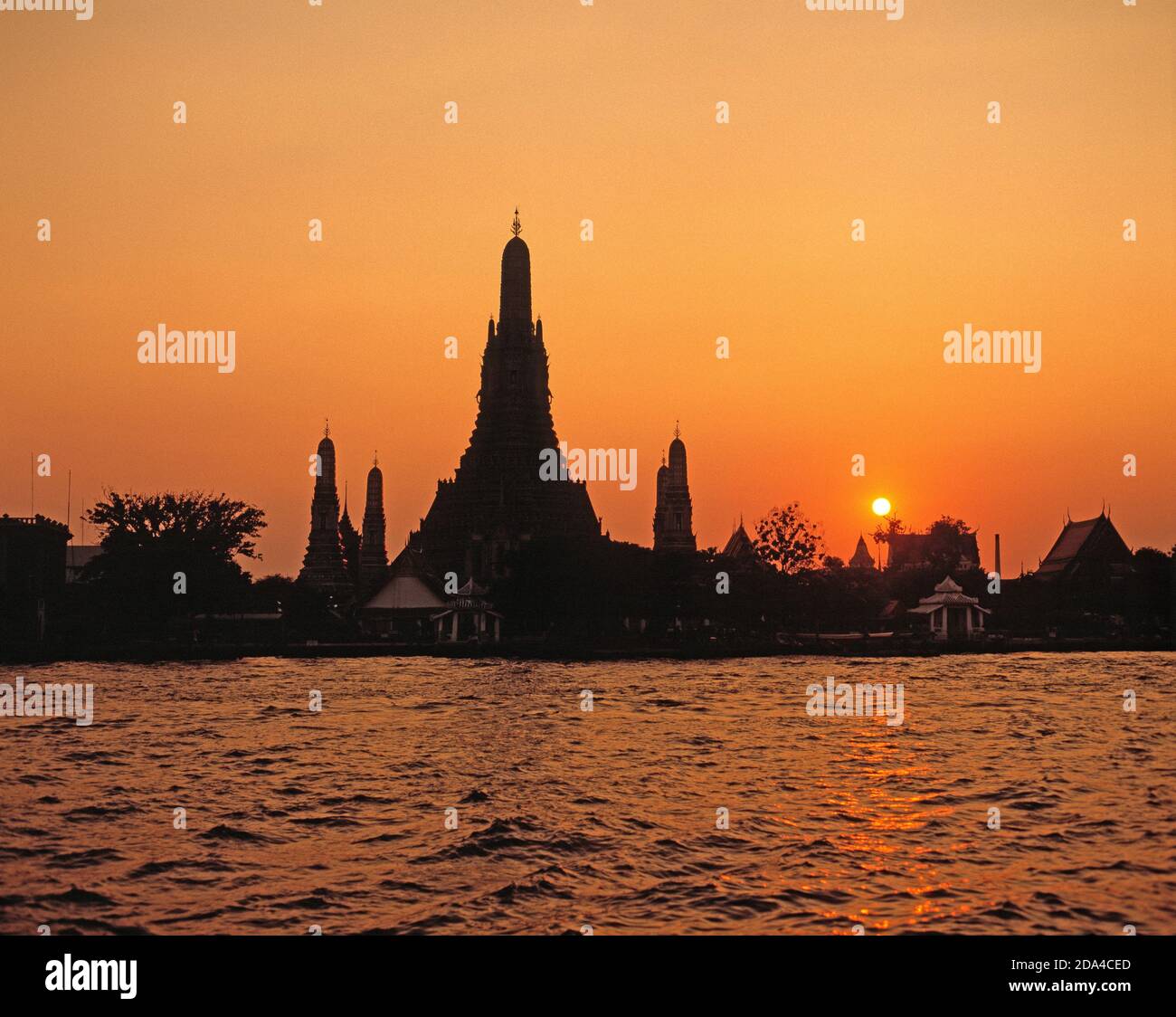 Thailand.  Bangkok. Wat Arun. View of temple buildings from across the Chao Phraya river at sunset. Stock Photo