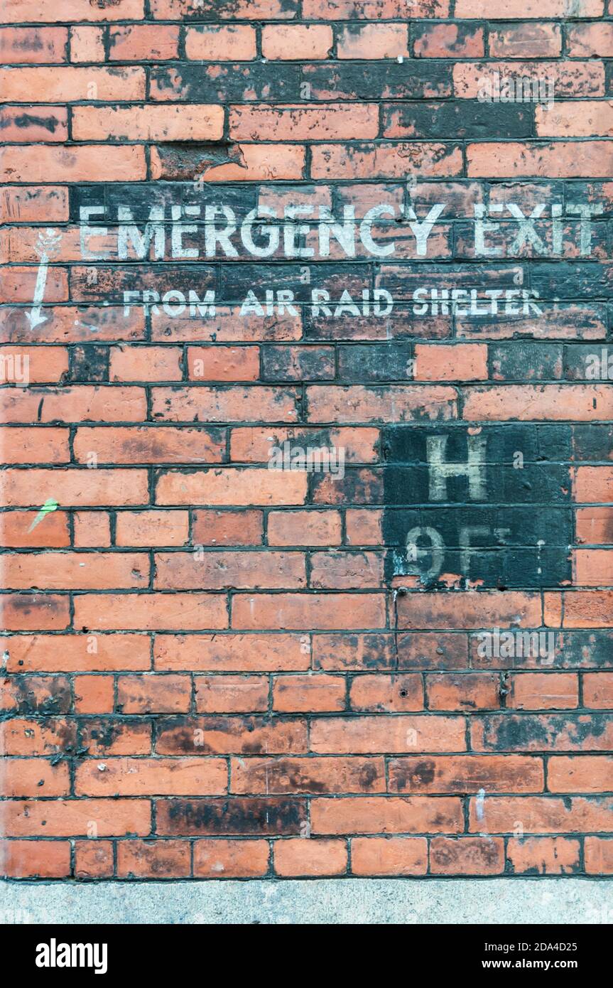 Second World War ghost sign reading Emergency Exit from air raid shelter on building in Eberle Street, Liverpool. Stock Photo