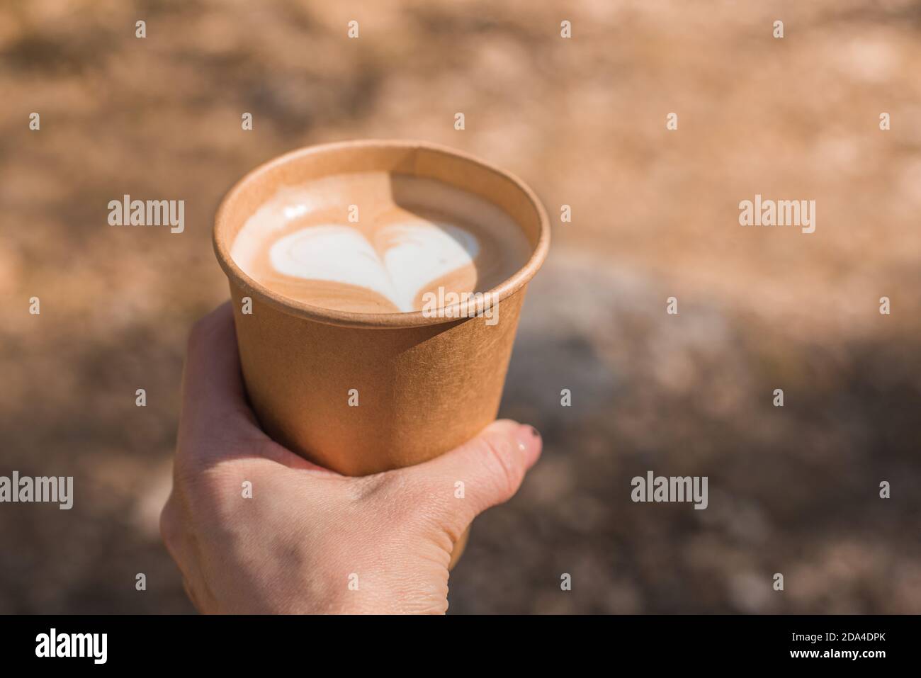hand holding paper cup of coffee on nature background Stock Photo - Alamy