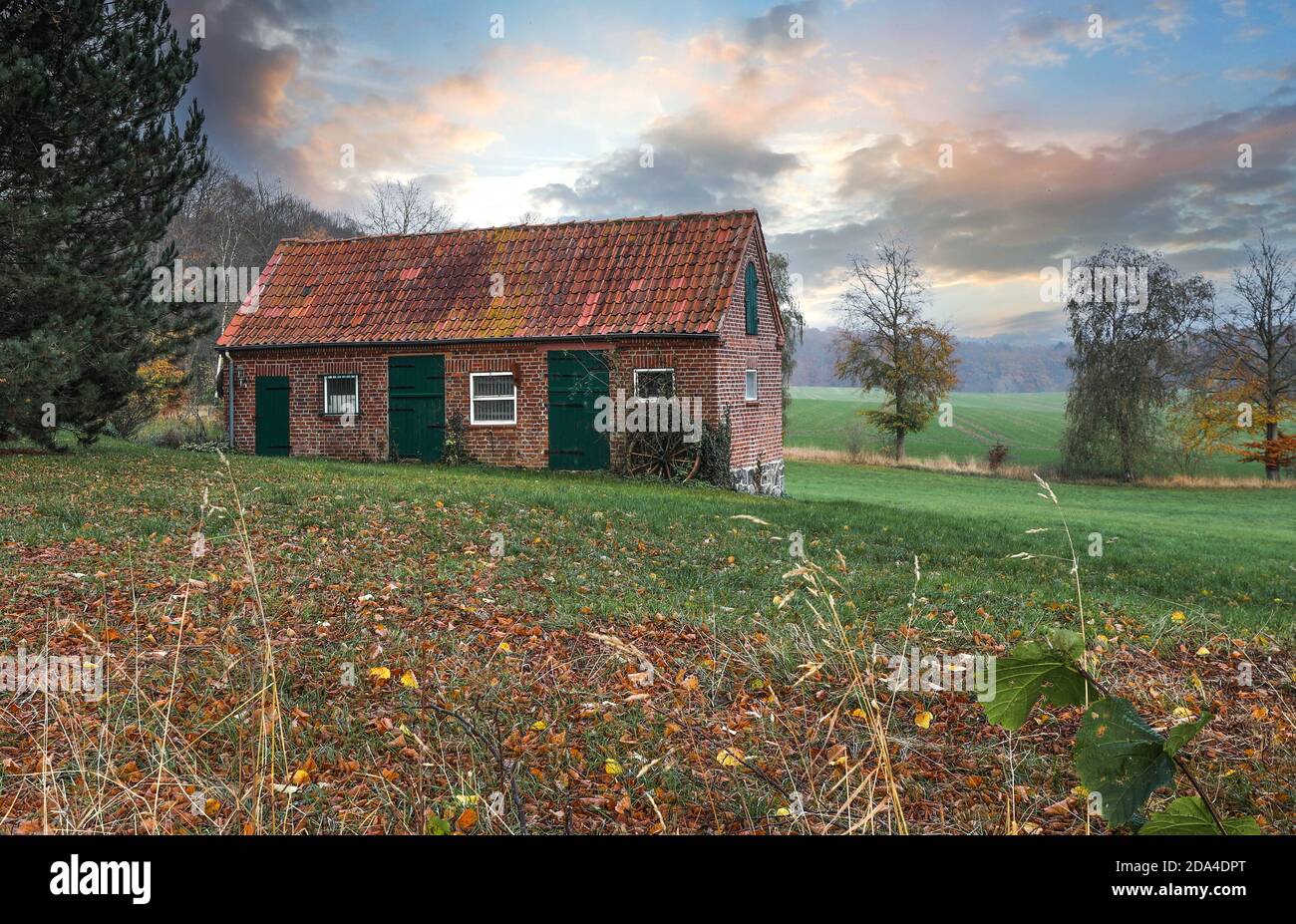 The outbuilding fits well into the hilly landscape of Holstein Switzerland. Stock Photo