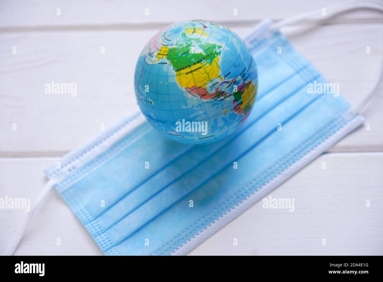 globe and medical face mask - global pandemic - corona covid concept with selective focus Stock Photo