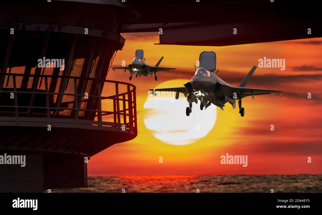 F-35 5th generation aircraft landing on an aircraft carrier against the background of the setting sun Stock Photo