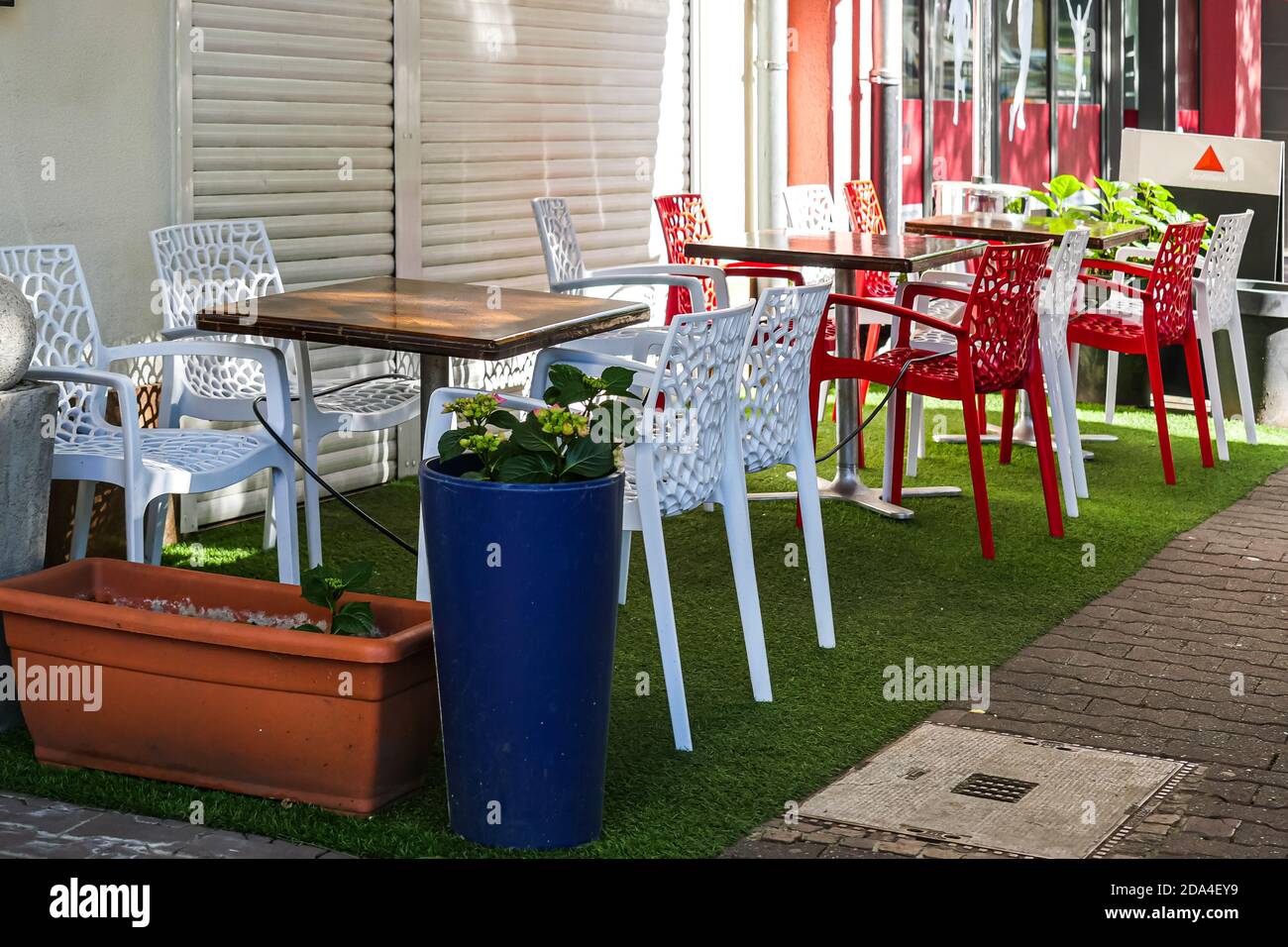 Vacant outdoor restaurant tables and chairs during covid restrictions. Long shot. Stock Photo