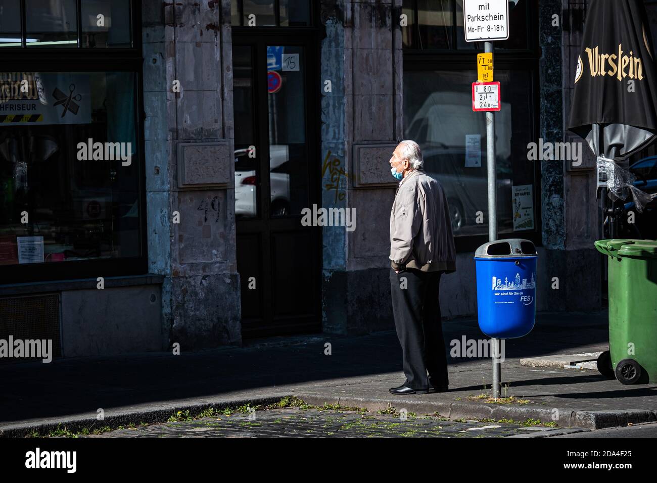 Spring 2020. Frankfurt, Germany. Old caucasian man standing on empty city street during corona virus lockdown. Long shot. Stock Photo