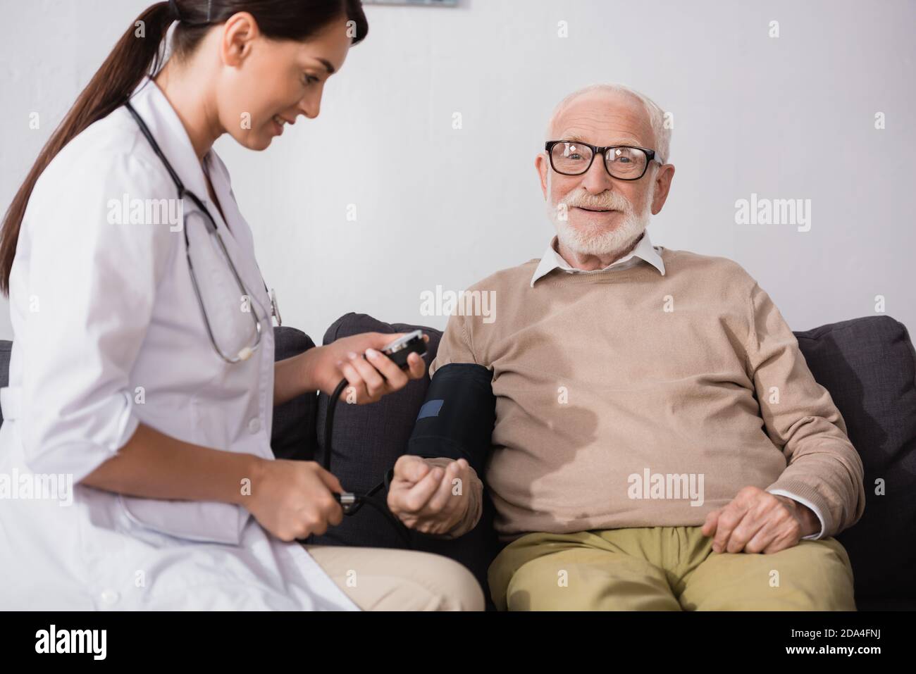 collage of geriatric nurse examining aged man with tonometer at home Stock Photo