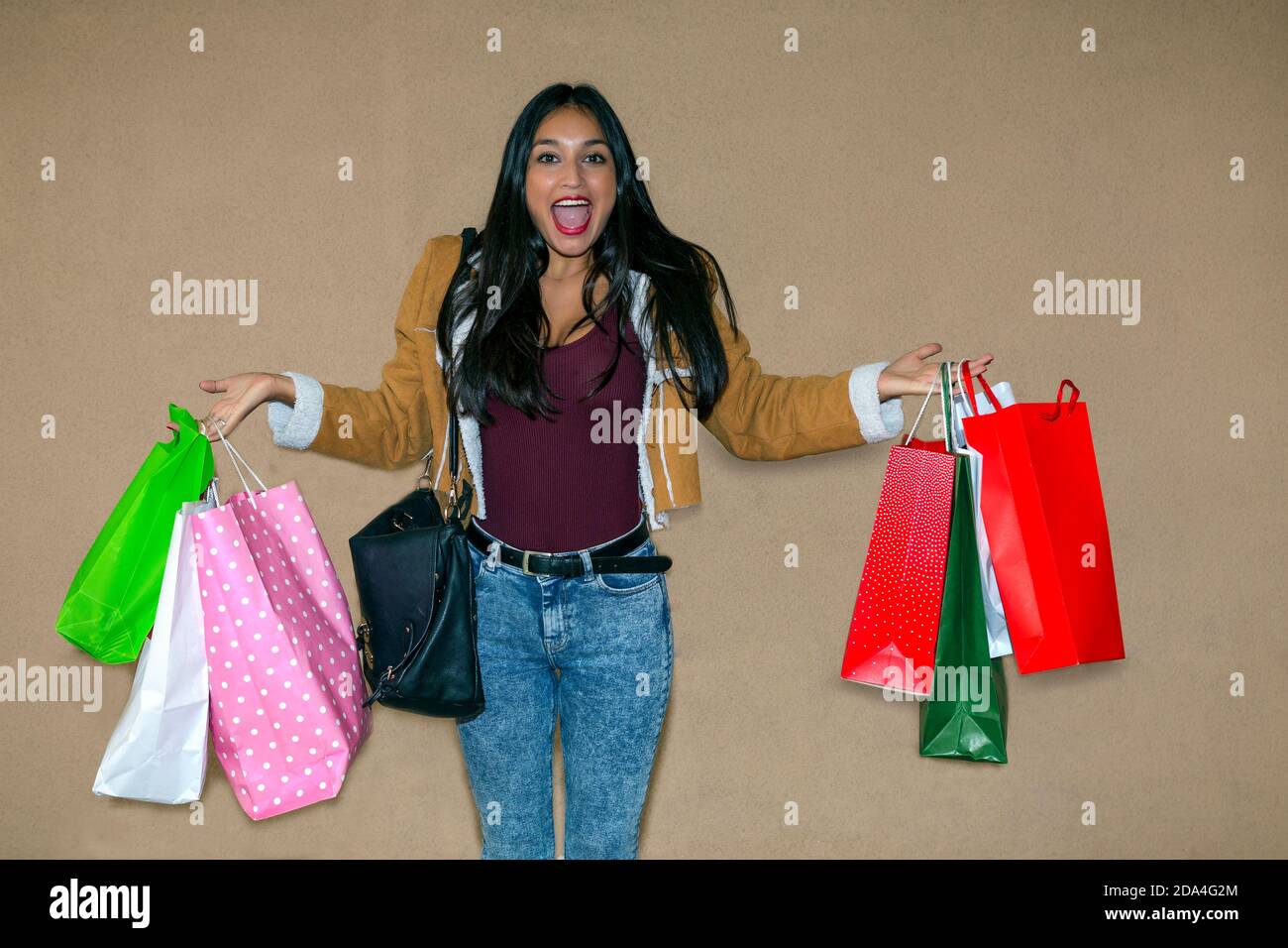 pretty long-haired brunette girl showing happy and expressive bags with purchases made in different stores Stock Photo