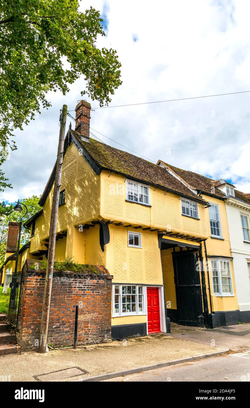 Yellow Tudor style house with wave crest pattern facade next to Church of St Mary the Virgin on Church Street, Baldock, Hertfordshire, UK Stock Photo