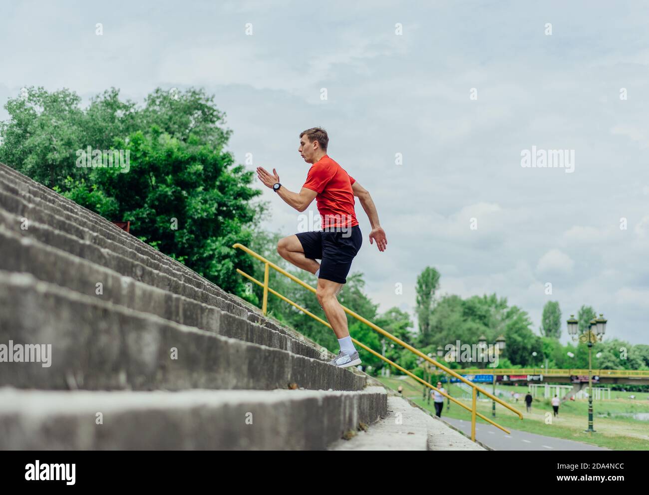 Fit male athlete performing stairs workout, running up climbing stairs
