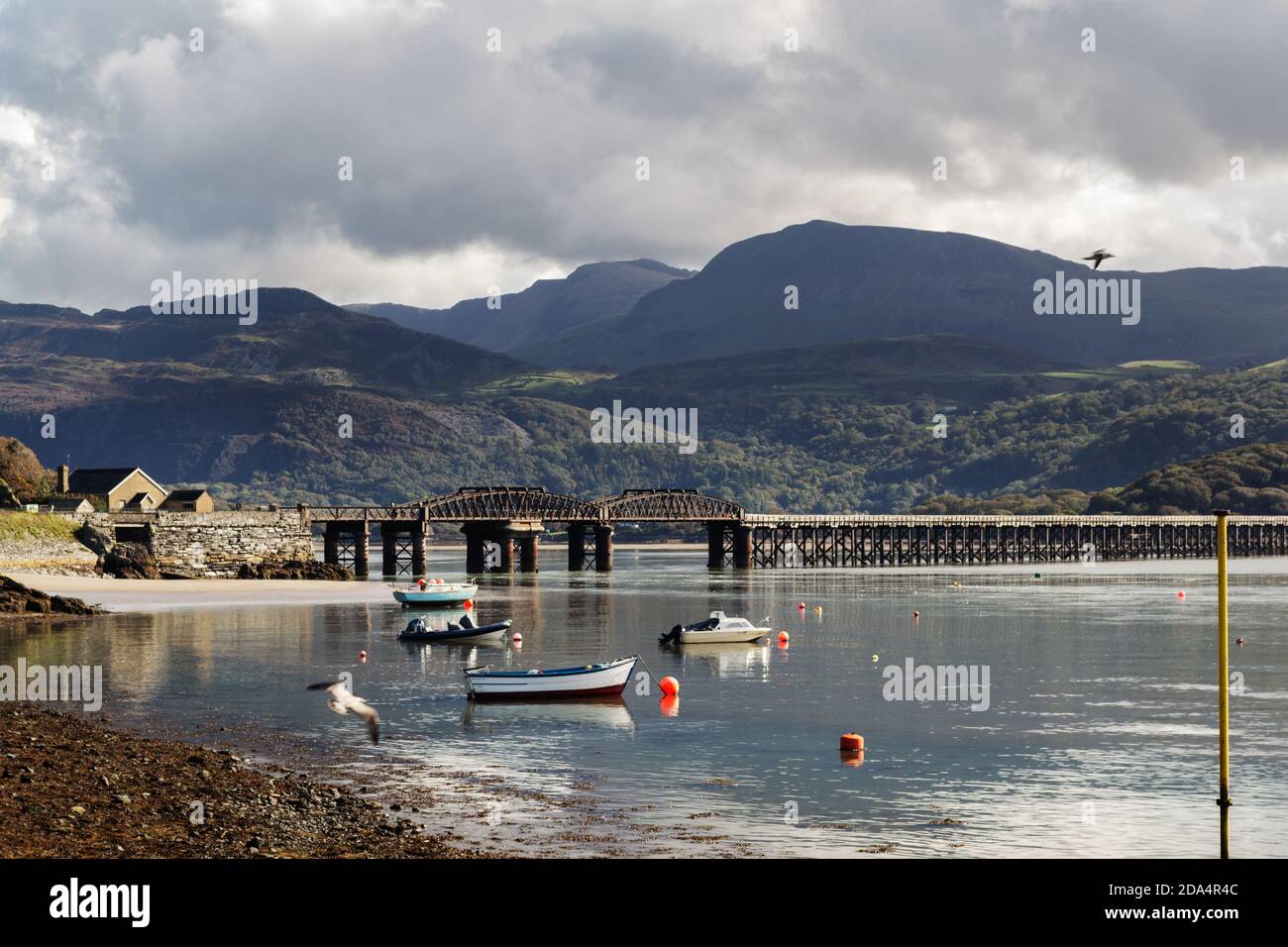 BARMOUTH, WALES - October 1st, 2020: boats in the Estuary of the river Mawddach,  and the viaduct, Barmouth, Wales, County of Gwynedd on a sunny autum Stock Photo